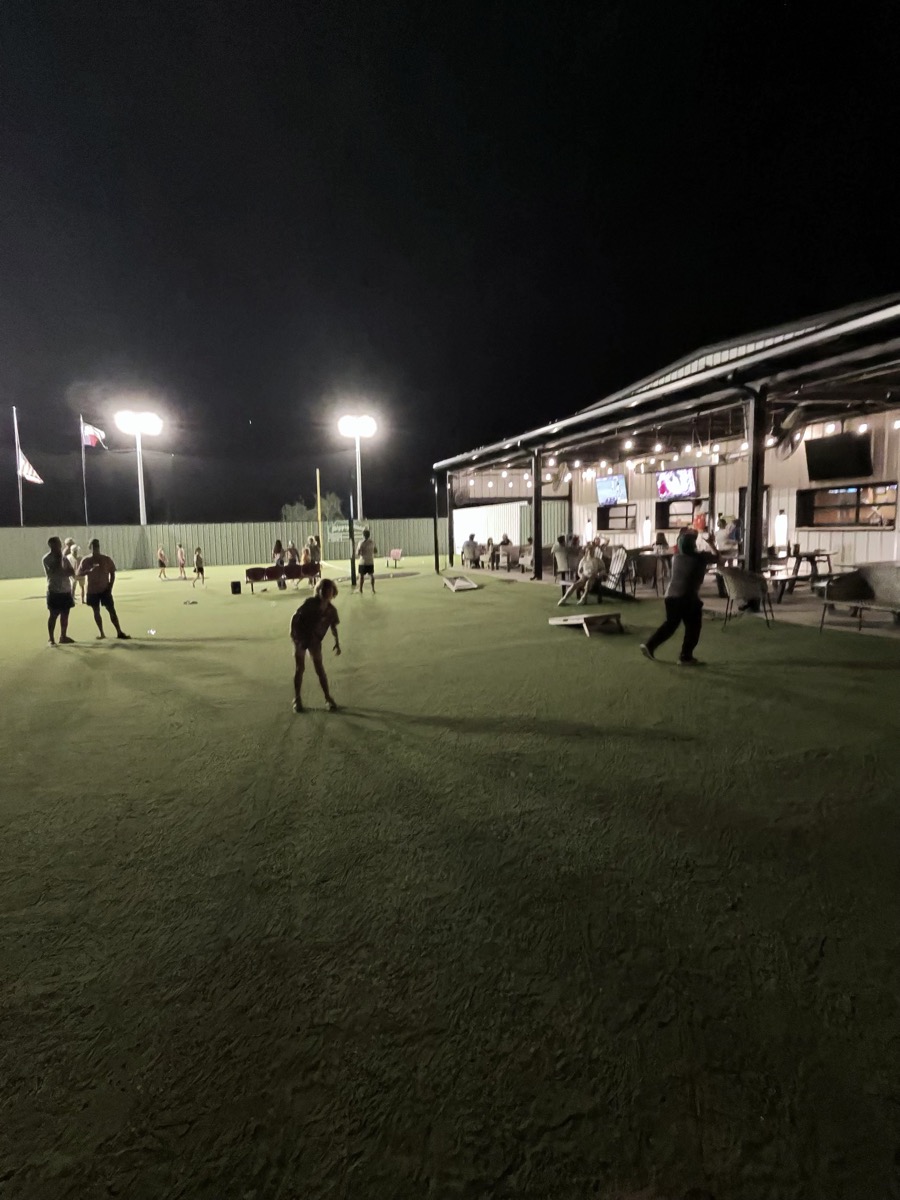 Children playing on Camp Briteside's turf field at night